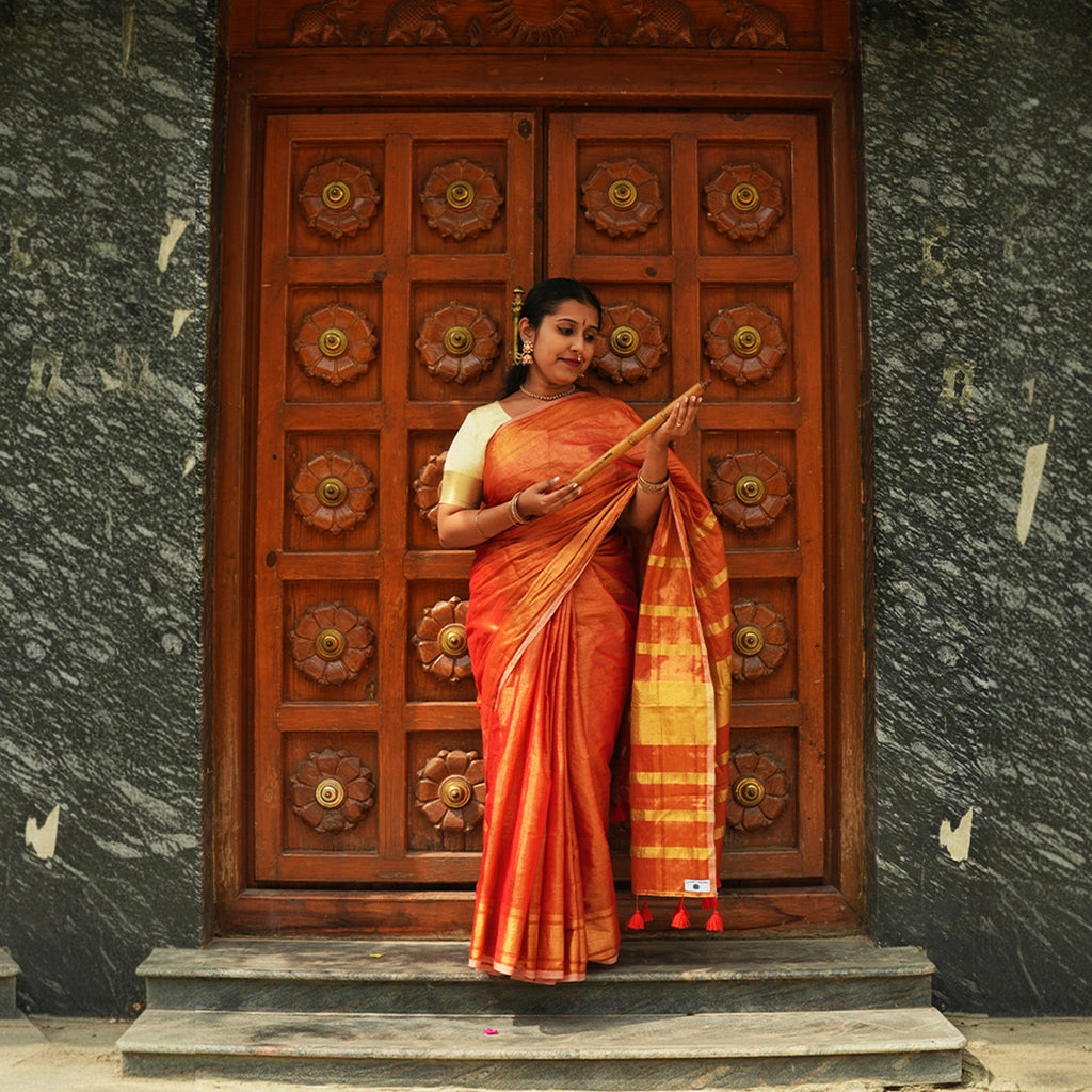 Model wearing Orange Raga Tissue Saree in handcrafted Indian silk with golden zari border – front view
