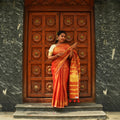 Model wearing Orange Raga Tissue Saree in handcrafted Indian silk with golden zari border – front view
