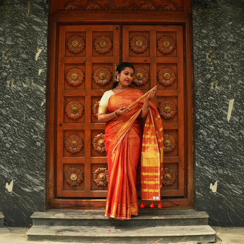 Model wearing Orange Raga Tissue Saree in handcrafted Indian silk with golden zari border – front view