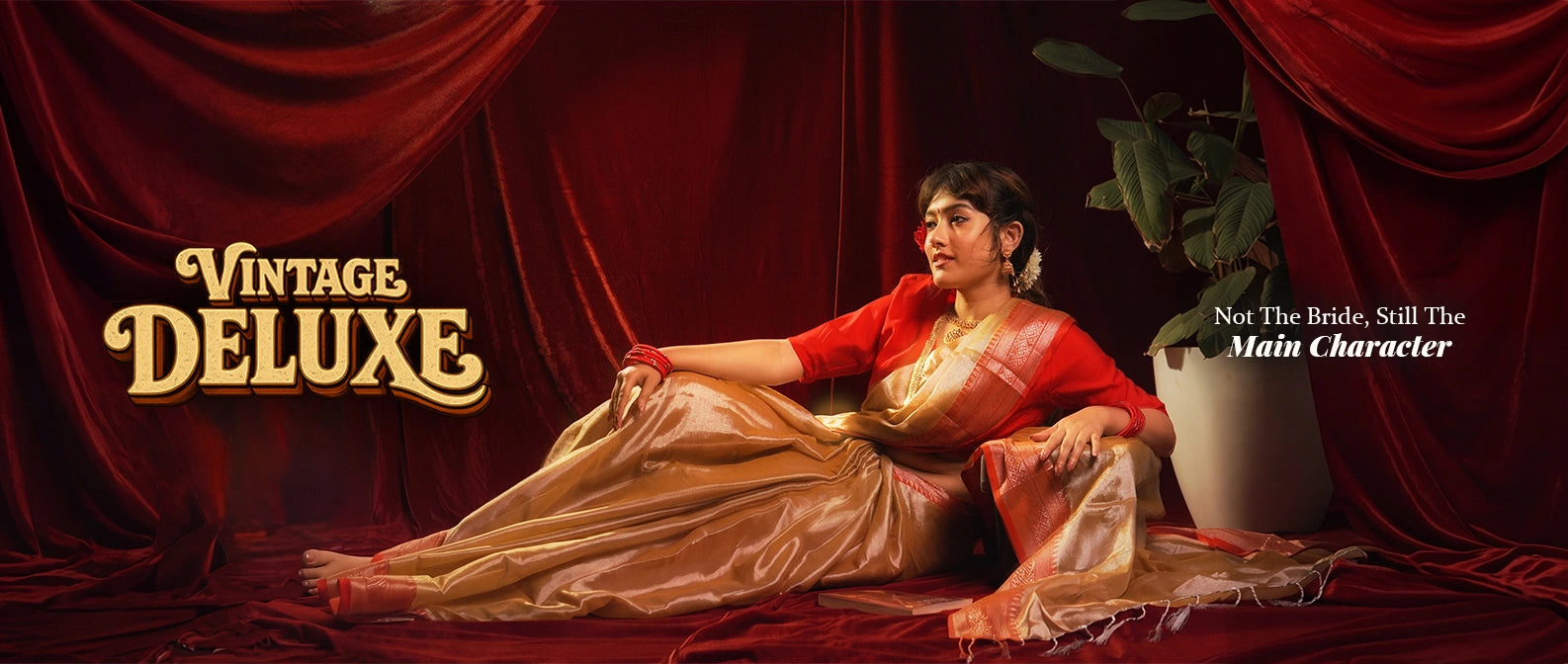 Woman reclining in a gold and red vintage deluxe main character saree against red curtains, Kottanz Loom Co