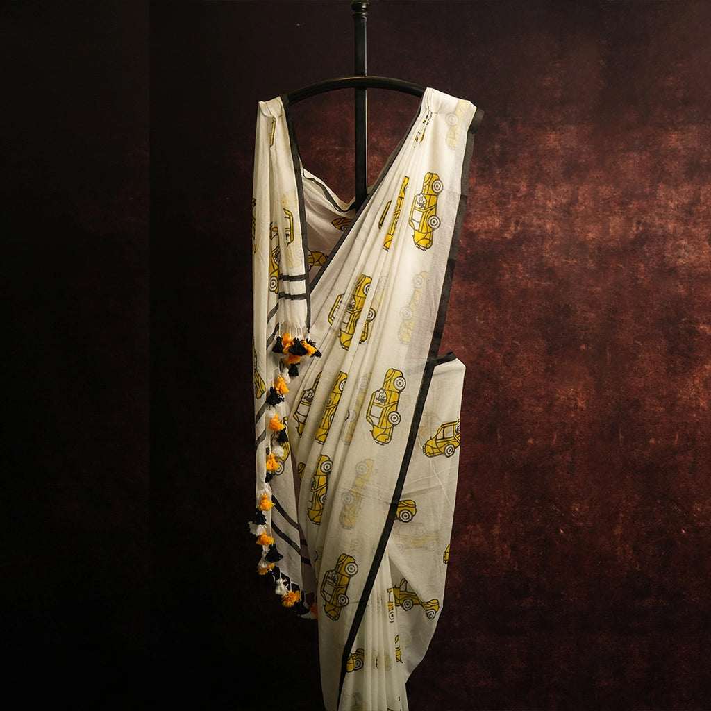 Close-up of red, white and yellow tassel detailing on vintage transport print saree pallu