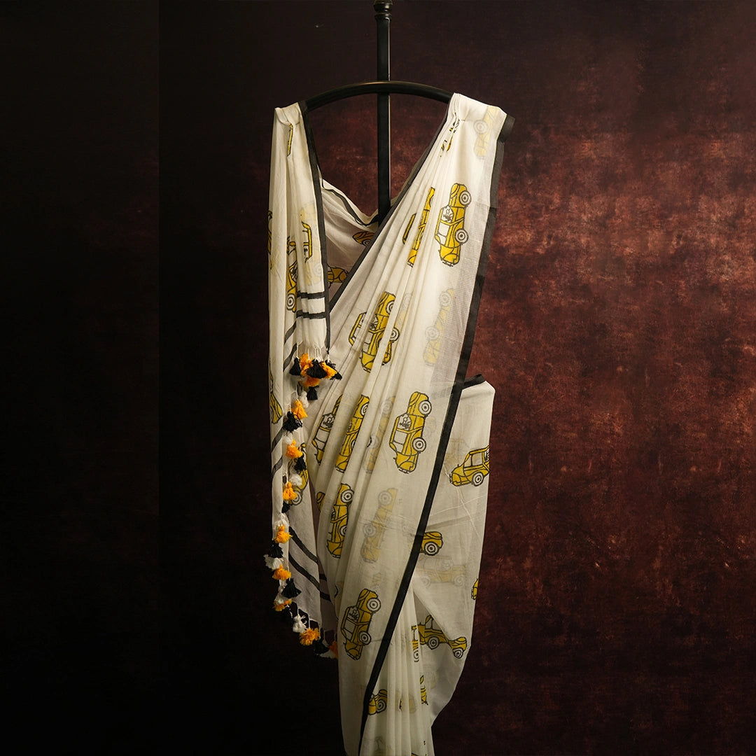 Close-up of red, white and yellow tassel detailing on vintage transport print saree pallu