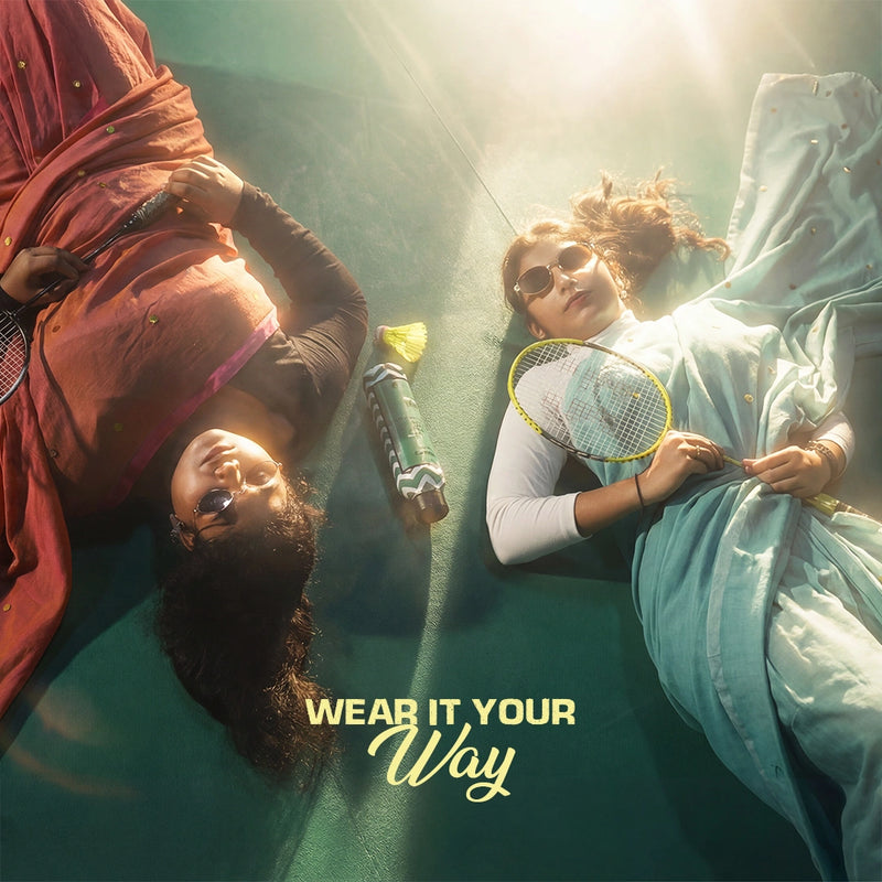 Two women lying on a badminton court wearing statement sarees with sunglasses and sports gear, Kottanz Loom Co